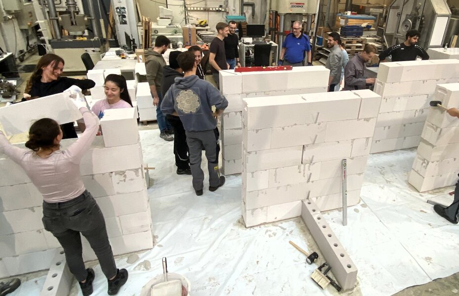 Studierende der Universität Duisburg-Essen errichten in Gruppen Mauerwerkskörper aus Porenbeton- und Kalksandsteinen steinen.