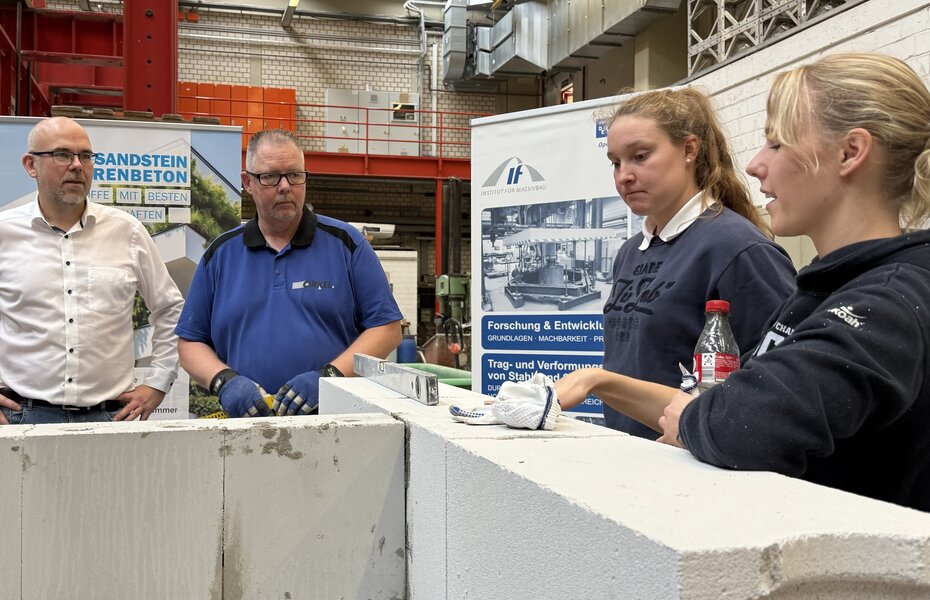 Studierende errichten beim Tag des Mauerwerks eine Wandkonstruktion aus Kalksandstein und Porenbeton.