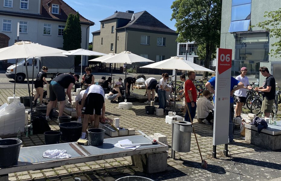 Architekturstudierende der Hochschule Anhalt mauern beim Tag des Mauerwerks in Dessau eigene Werkstücke und verbinden Theorie mit praktischer Bauerfahrung.