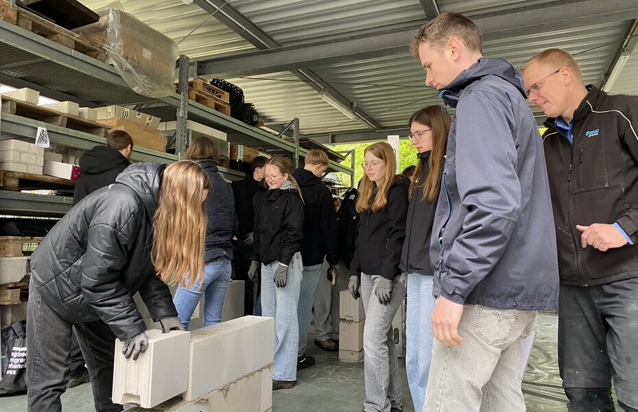 Studierende der FH Münster arbeiten mit Mauersteinen und sammeln praktische Erfahrungen im Mauerwerksbau.